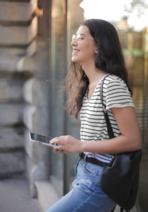 Young woman in striped shirt holds tablet