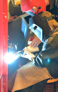 student in safety gear welds in lab